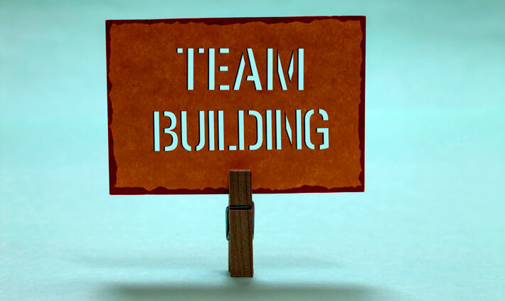 Ein Team zusammenführen: Zettel mit Aufschrift "Teambuilding"